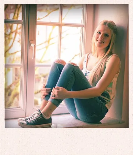 Junge Frau sitzt im Fenster